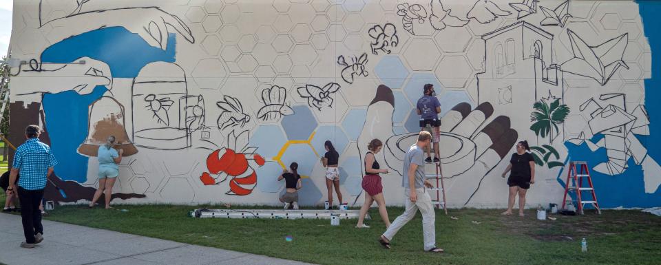 People work on a mural at the first day of painting at Leesburg High School in Leesburg on Tuesday, May 24, 2022. [PAUL RYAN / CORRESPONDENT]