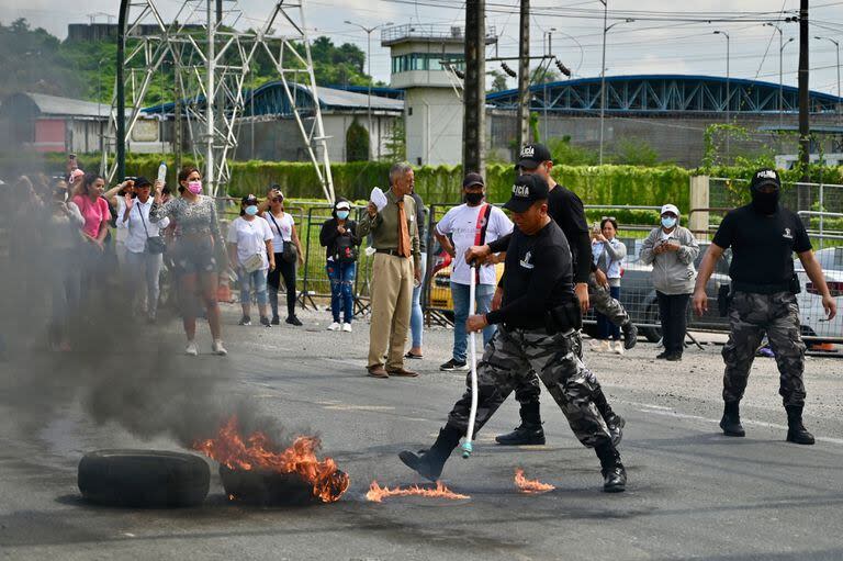 Miembros de la policía despejan la carretera durante una protesta de familiares de reclusos en los alrededores del complejo penitenciario Regional 8 en Guayaquil, Ecuador, el 28 de marzo de 2024.