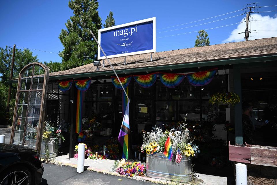 A Pride flag ripped off its flag pole is seen outside the entrance to the Mag.Pi clothing store in Cedar Glen, near Lake Arrowhead, California, on August 21, 2023. The owner of the store, Laura Ann Carleton, was fatally shot Aug. 18 by a man who "made several disparaging remarks about a rainbow flag," according to the San Bernardino County Sheriff's Department.