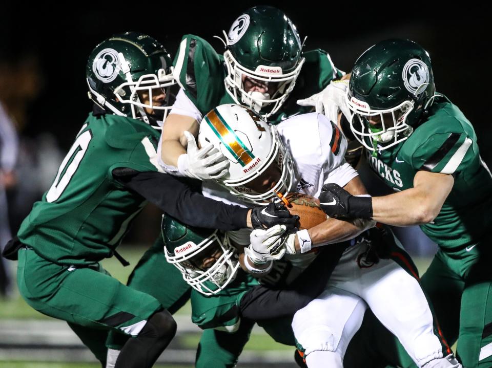 The Trinity defense stops Frederick Douglass' Pharo Watts in the fourth quarter. The Rocks defeated Frederick Douglass, 14-7, in overtime in a Class 6A state semifinal Friday night.