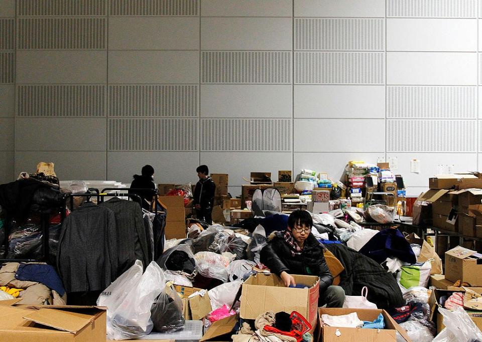 Image of volunteers sorting through clothes and other relief supplies at a Fukushima shelter in 2011, shortly after the nuclear disaster.