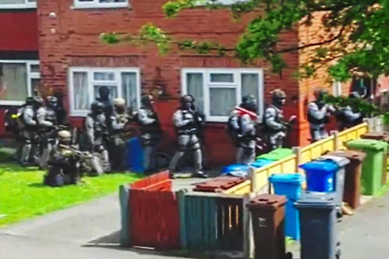 Ready to roll: armed police prepare to raid a house in Fallowfield, Manchester, following Monday's bombing