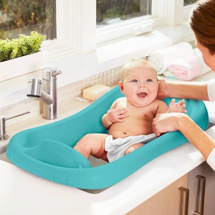 A baby in an infant bathtub
