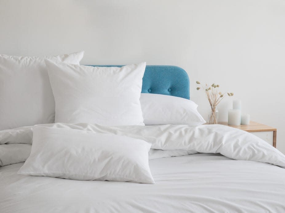 White pillows, duvet and duvet case on a blue bed.