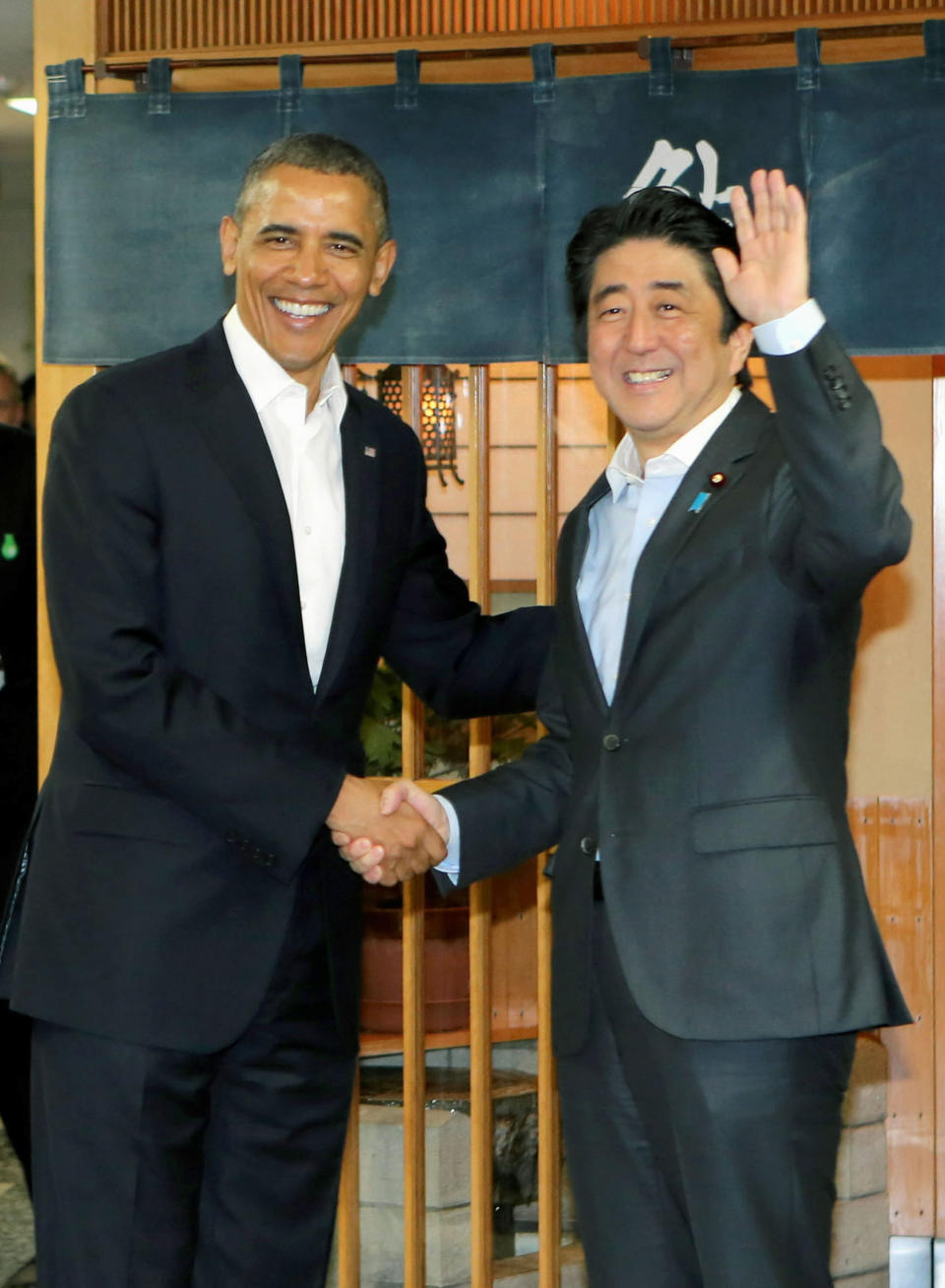 Obama and Abe shake hands in front of Sukiyabashi Jiro sushi restaurant. (Photo: Pool/Kyodo News via Getty Images)