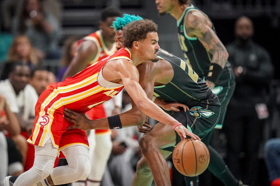 Atlanta Hawks guard Trae Young, front, drives into a foul by Charlotte Hornets forward Kai Jones, right, during the first half of an NBA basketball game Friday, Dec. 16, 2022, in Charlotte, N.C. (AP Photo/Rusty Jones)