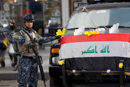 A member of security forces flashes the victory sign, during marking the one year anniversary of the military defeat of Islamic State, at Tahrir square in Baghdad, Iraq December 10, 2018. REUTERS/Thaier al-Sudani