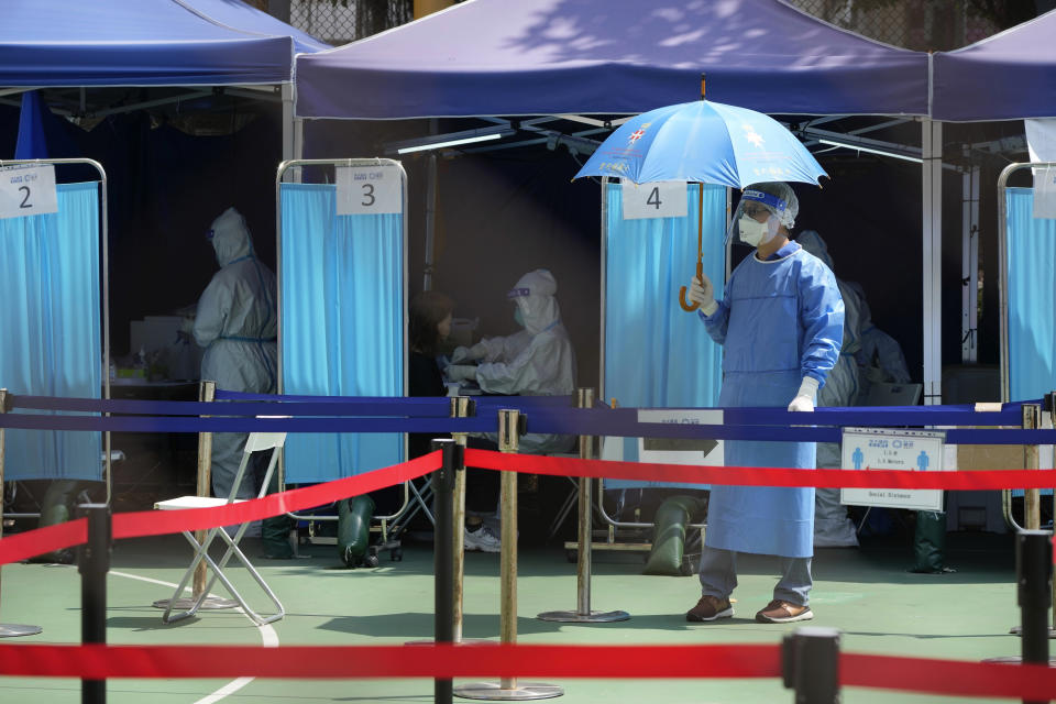 Workers wearing protective gear at a temporary testing center.