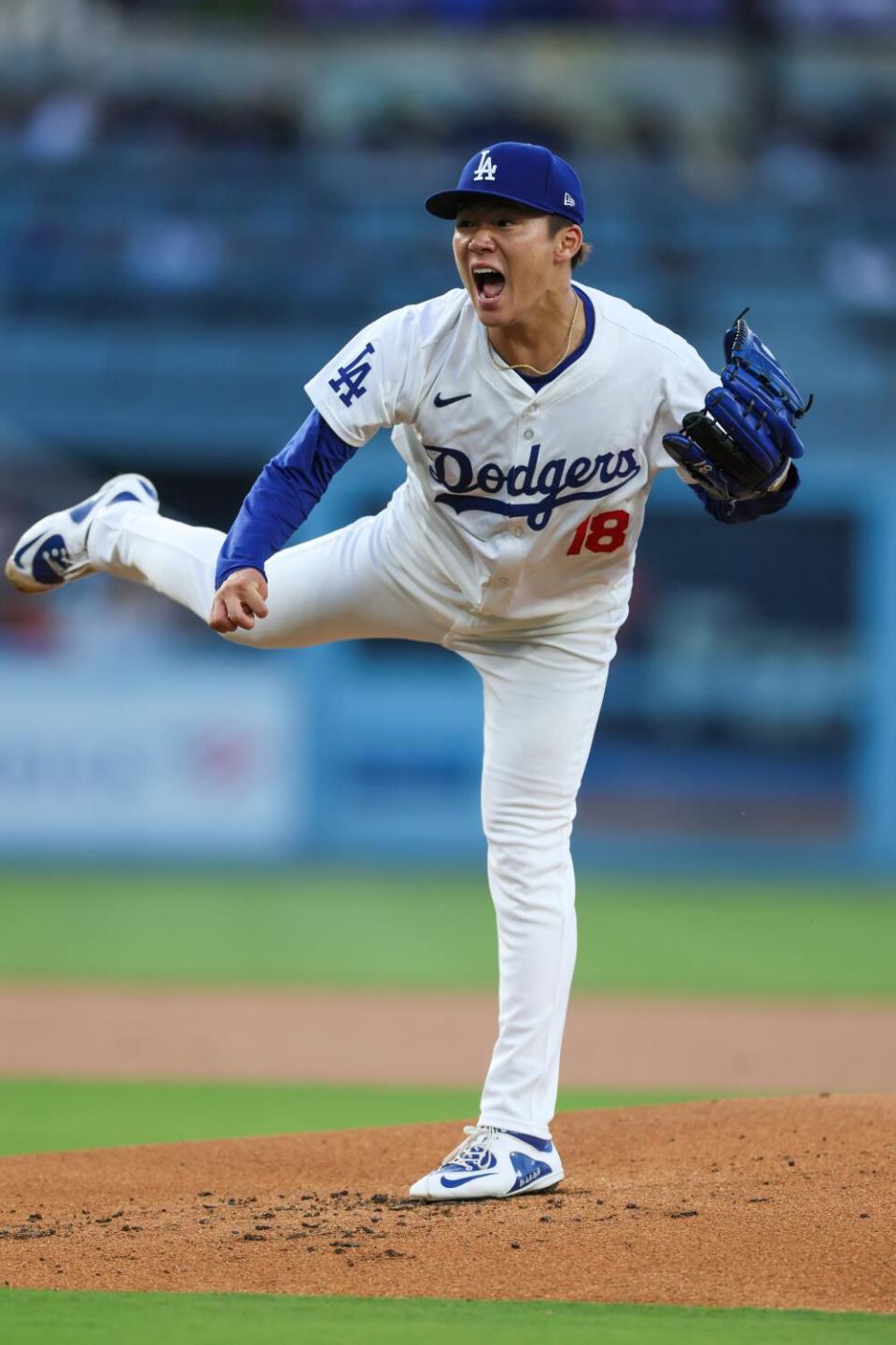Dodgers starting pitcher Yoshinobu Yamamoto yells out as he throws a pitch in the first inning against the Colorado Rockies.