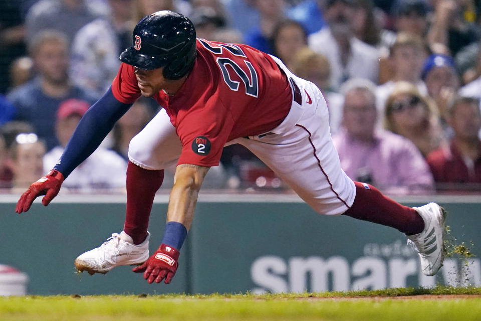 Boston Red Sox's Tommy Pham dives home to score on a double by Rafael Devers during the third inning of a baseball game against the Toronto Blue Jays, Thursday, Aug. 25, 2022, in Boston. (AP Photo/Charles Krupa)