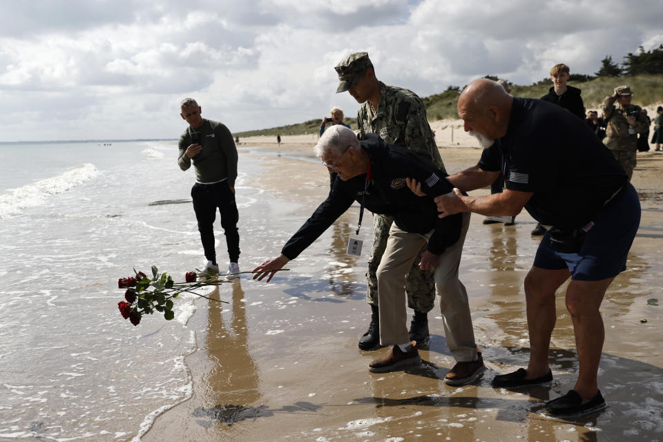 American WWII veteran Bill Wall throws roses into the water during a wreath-laying ceremony at Utah Beach, Wednesday, June 5, 2024 at Utah Beach, Normandy. (AP Photo/Jeremias Gonzalez)