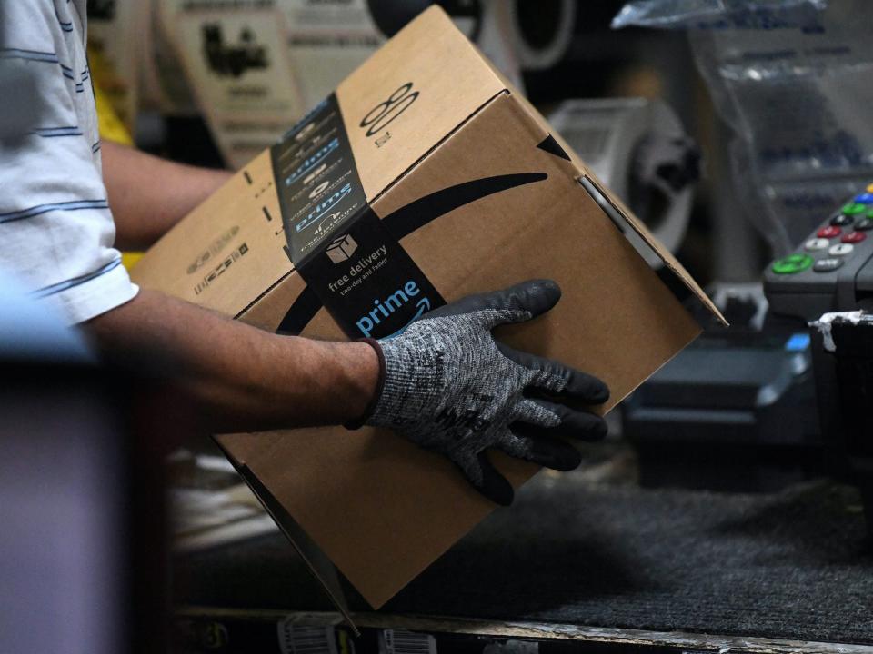 A worker assembles a box for delivery at an Amazon fulfillment center