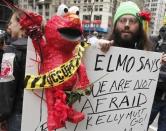 An Occupy Wall Street movement supporter holds up a sign with Elmo before a march from Zuccotti Park to Union Square to protest perceived police brutality in New York, March 24, 2012.