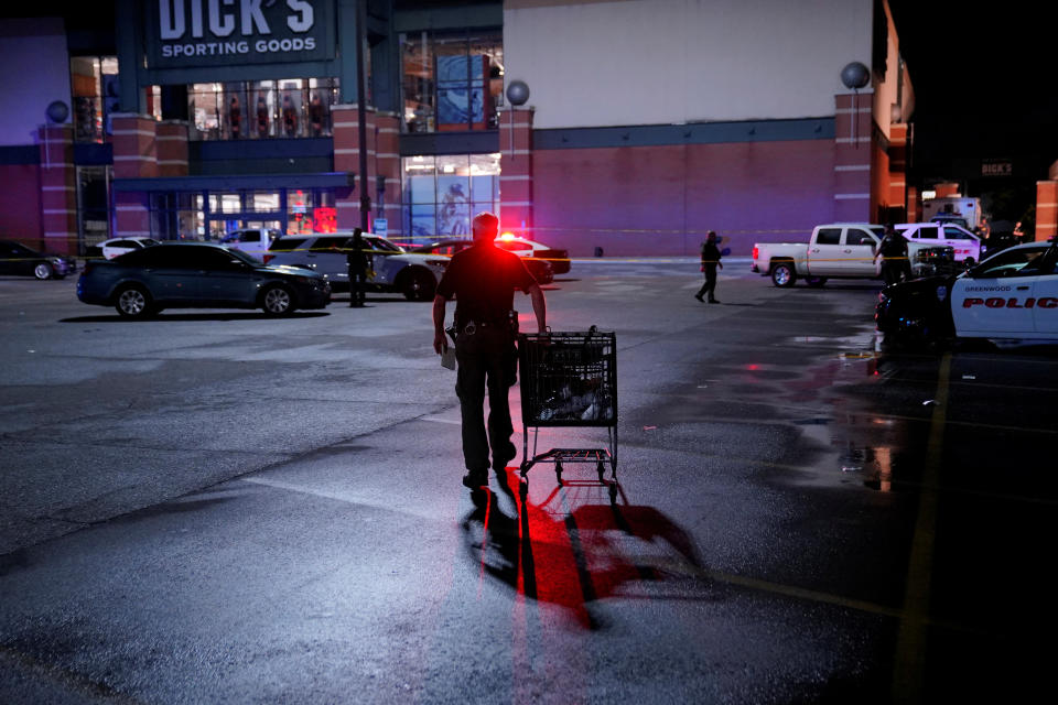 A law enforcement officer pushes a shopping cart after a shooting at a mall in the Indianapolis suburb of Greenwood, Indiana, U.S. July 17, 2022.  REUTERS/Cheney Orr
