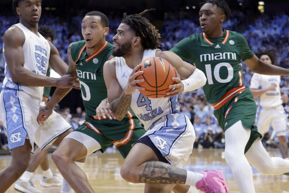 North Carolina guard RJ Davis (4) drives against Miami guards Matthew Cleveland (0) and Paul Djobet (10) during the first half of an NCAA college basketball game Monday, Feb. 26, 2024, in Chapel Hill, N.C. (AP Photo/Chris Seward)