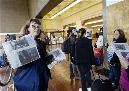 Los Angeles Register managing editor Donna Ware (L) hands out the debut issue of their newspaper to commuters at Union Station in Los Angeles April 16, 2014. REUTERS/Kevork Djansezian