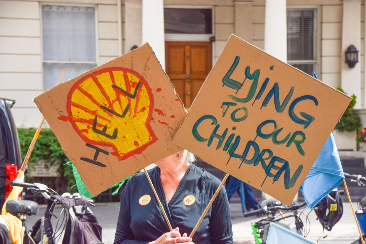 A demonstrator holds anti-Shell placards outside the Science Museum during the anti-Shell sponsorship protest.