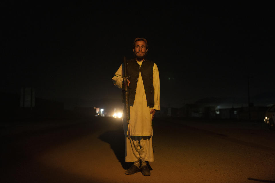 A Taliban fighter poses for a photo at a check point in Herat Afghanistan, on Saturday, Nov. 27, 2021. Since the Taliban's takeover of Afghanistan just over three months ago amid a chaotic withdrawal of U.S. and NATO troops, its fighters have changed roles, turning from fighting in the mountains and the fields to running the country. (AP Photo/ Petros Giannakouris)