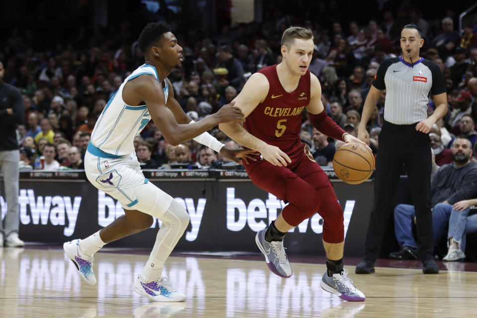 Cleveland Cavaliers guard Sam Merrill (5) drives against Charlotte Hornets forward Brandon Miller (24) during the first half of an NBA basketball game, Monday, March 25, 2024, in Cleveland. (AP Photo/Ron Schwane)