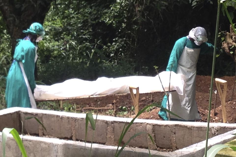 Health workers carry the body of an Ebola virus victim in Kenema, Sierra Leone, June 25, 2014. The Ebola outbreak has killed 467 people in Guinea, Liberia and Sierra Leone since February, making it the largest and deadliest ever, according to the World Health Organization (WHO). West African states lack the resources to battle the world's worst outbreak of Ebola and deep cultural suspicions about the disease remain a big obstacle to halting its spread, ministers said on Wednesday. Picture taken June 25, 2014. REUTERS/Umaru Fofana (SIERRA LEONE - Tags: HEALTH SOCIETY)