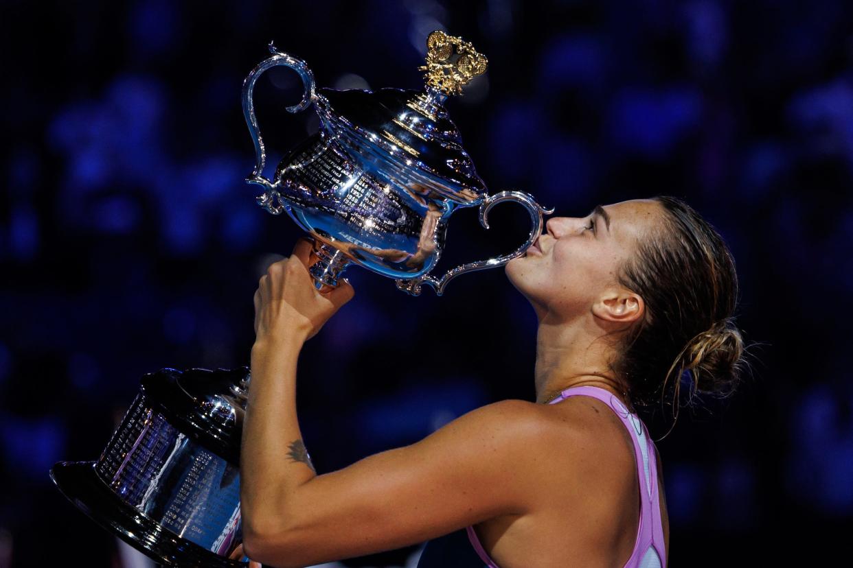 Aryna Sabalenka kisses the Daphne Akhurst Memorial Cup after winning the 2023 Australian Open.