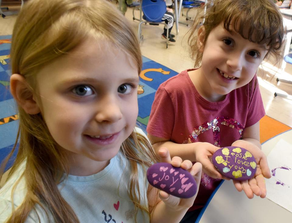 Dundee Elementary School first graders Violet Puckett, left, and Rosie Dilley painted "Joy" and "I Love You" on their rocks for their teacher, Jenny Dolezal.