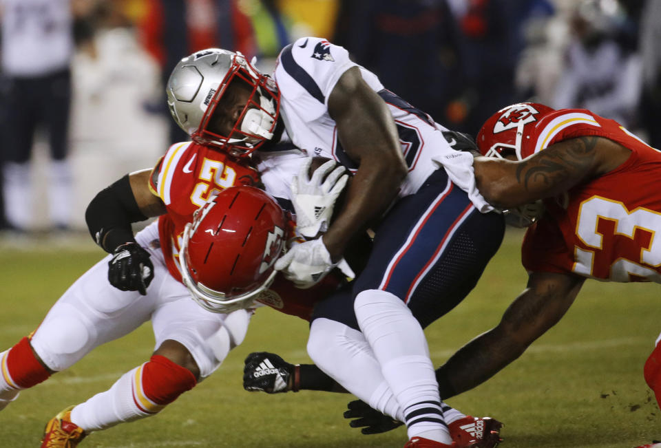 New England Patriots running back Sony Michel (26) is tackled by Kansas City Chiefs defensive back Eric Berry (29) and inside linebacker Anthony Hitchens (53) during the first half of the AFC Championship NFL football game, Sunday, Jan. 20, 2019, in Kansas City, Mo. (AP Photo/Charlie Riedel)