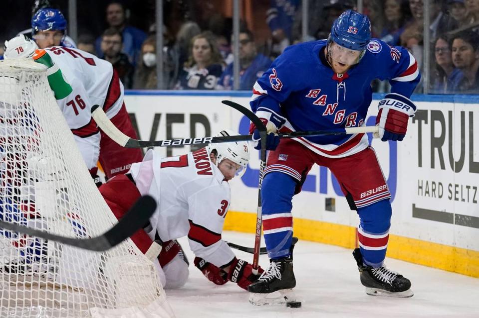 New York Rangers defenseman Adam Fox (23) clears the puck from Carolina Hurricanes right wing Andrei Svechnikov (37) from behind the net in the first period of Game 4 of an NHL hockey Stanley Cup second-round playoff series, Tuesday, May 24, 2022, in New York.