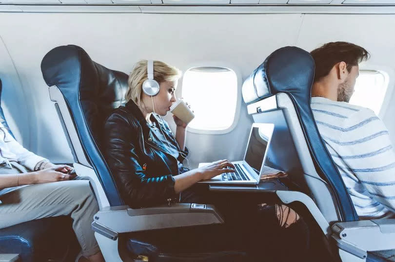 Woman drinking hot drink on plane