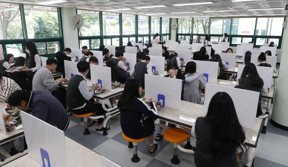 High school students eat a lunch at a school cafeteria which has screens on tables for preventing infections, as schools reopen following the global outbreak of the coronavirus disease (COVID-19), in Ulsan, South Korea, May 20, 2020.