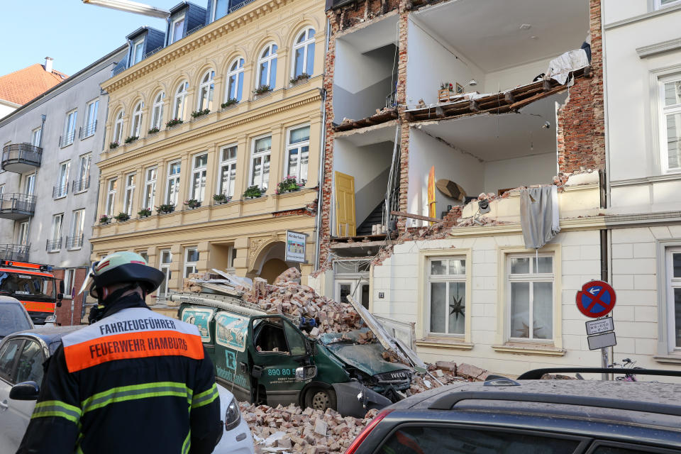 Trümmer liegen vor dem Haus, dessen Fassade eingestürzt ist. (Bild: Bodo Marks/dpa)
