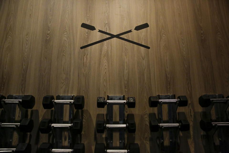 Weights are seen hanging on the wall at CITYROW Atlanta Midtown as gyms reopen with limited members on Saturday, May 16, 2020, amid the COVID-19 virus in Atlanta. Big box gyms and local fitness studios are reopening under a patchwork of protocols based on state and local guidance, but most are following some basic protocol. (AP Photo/Brynn Anderson)