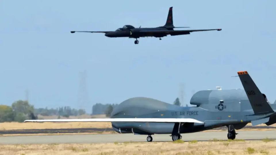 A TU-2S comes in to land while an RQ-4 Global Hawk sits in the foreground. <em>USAF</em>
