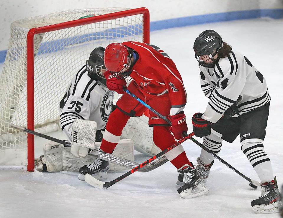 Silver Lake's Mark Kelleher tries to get a shot off in the crease under pressure from Whitman-Hanson goalie Erik Dean and Luke Tropeano on Friday January 28, 2022.