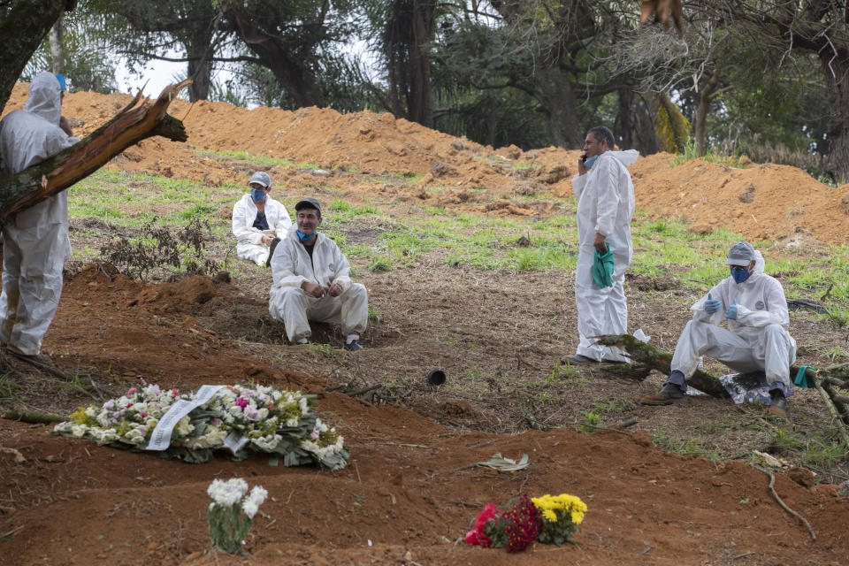 Cemetery workers rest as they wait for more burials of COVID-19 victims at the Sao Luiz cemetery in Sao Paulo, Brazil, Thursday, June 4, 2020. (AP Photo/Andre Penner)