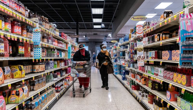 FILE PHOTO: Shoppers browse in a supermarket while wearing masks in St Louis