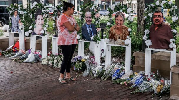 PHOTO: A woman looks a photographs of victims at a memorial near the scene of a mass shooting that took place at a 4th of July celebration and parade in Highland Park, Ill., July 7, 2022. (Tannen Maury/EPA via Shutterstock)