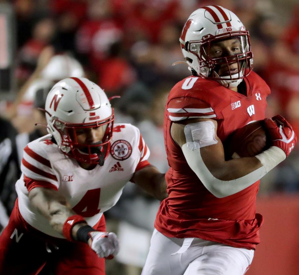 Wisconsin running back Braelon Allen (0) runs past Nebraska safety Myles Farmer (4) enroute to a 53-yard touchdown run during the fourth quarter of their game Saturday, November 20, 2021 at Camp Randall Stadium in Madison, Wis. Wisconsin beat Nebraska 35-28.