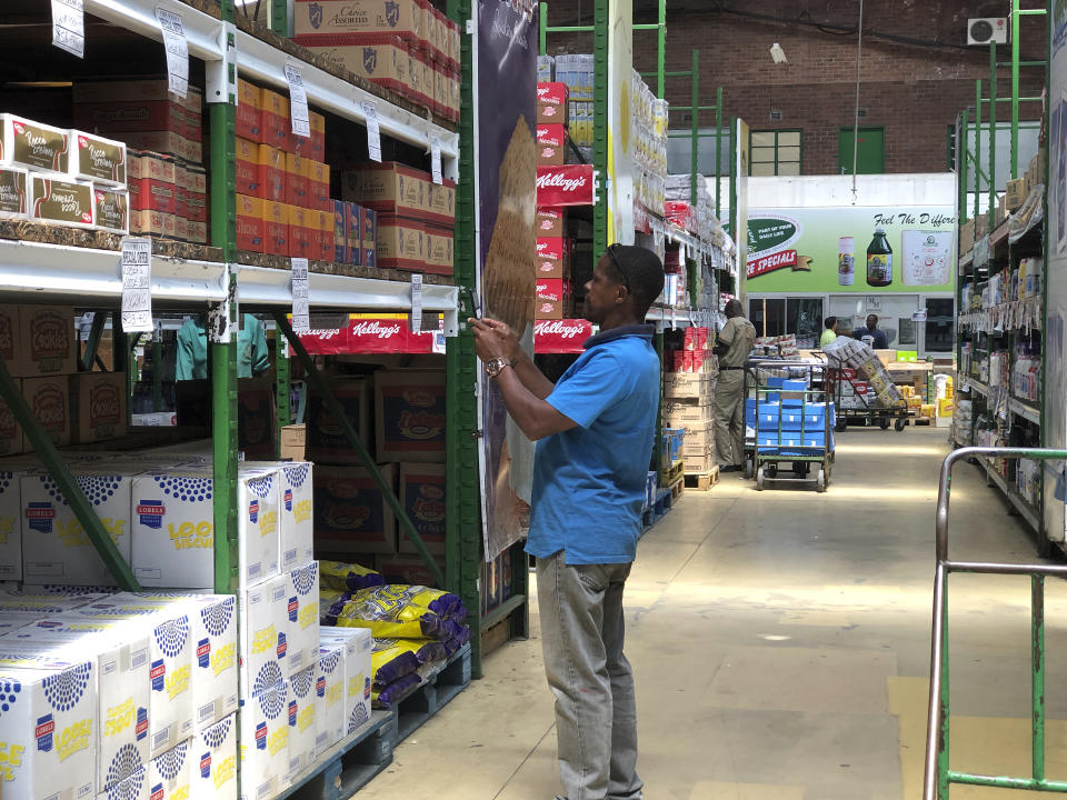 A man takes images of goods in a shop to share before buying them in Harare, in this Wednesday, Oct, 9, 2019 photo. Hyperinflation is changing prices so quickly in the southern African nation that what you would see displayed on a supermarket shelf might change by the time you reach the checkout. (AP Photo/Tsvangirayi Mukwazhi)