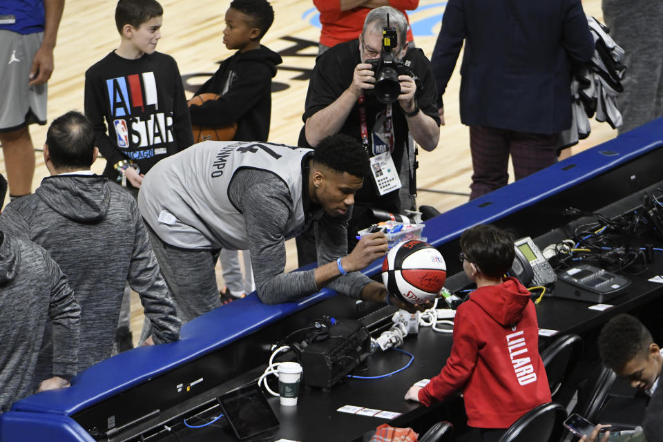 Milwaukee Bucks' Giannis Antetokounmpo signs an autograph during practice at the NBA All-Star basketball game, Saturday, Feb. 15, 2020, in Chicago. (AP Photo/David Banks)