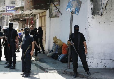 Hamas militants surround Palestinians suspected of collaborating with Israel, before their execution in Gaza City August 22, 2014. Hamas militants killed seven Palestinians suspected of collaborating with Israel in a public execution in a central Gaza square on Friday, witnesses and a Hamas website said. REUTERS/Stringer