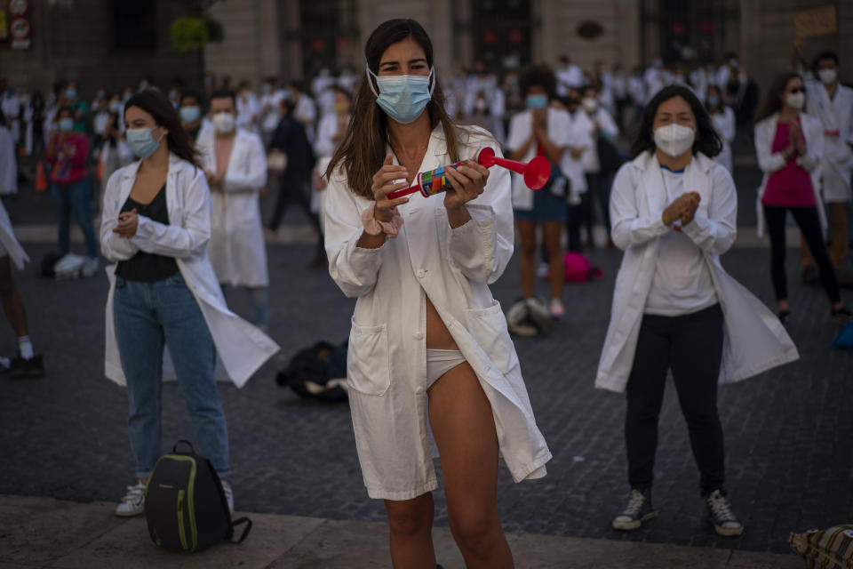 Medical residents, who removed their clothes to protest against working conditions, take part on a protest during a strike in Barcelona, Spain, Tuesday, Oct. 20, 2020. Regional authorities across Spain continue to tighten restrictions against a sharp resurgence of coronavirus infections that is bringing the country’s cumulative caseload close to one million infections, the highest tally in western Europe. (AP Photo/Emilio Morenatti)