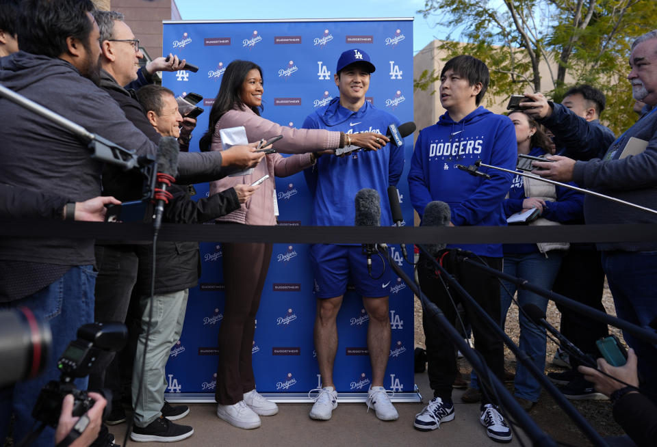 Shohei Ohtani de los Dodgers de Los Ángeles, junto al intérprete Ippei Mizuhara (derecha) conversan con los medios de comunicación en Camelback Ranch, en Phoenix, el viernes 9 de febrero de 2024. (AP Foto/Carolyn Kaster)