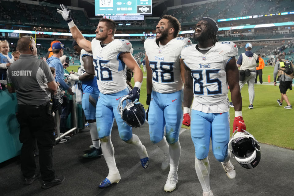 Tennessee Titans tights end Kevin Rader (86), Trevon Wesco (88) and Chigoziem Okonkwo (85) celebrates at the end of an NFL football game, Monday, Dec. 11, 2023, in Miami. The Titans defeated the Dolphins 28-27. (AP Photo/Lynne Sladky)