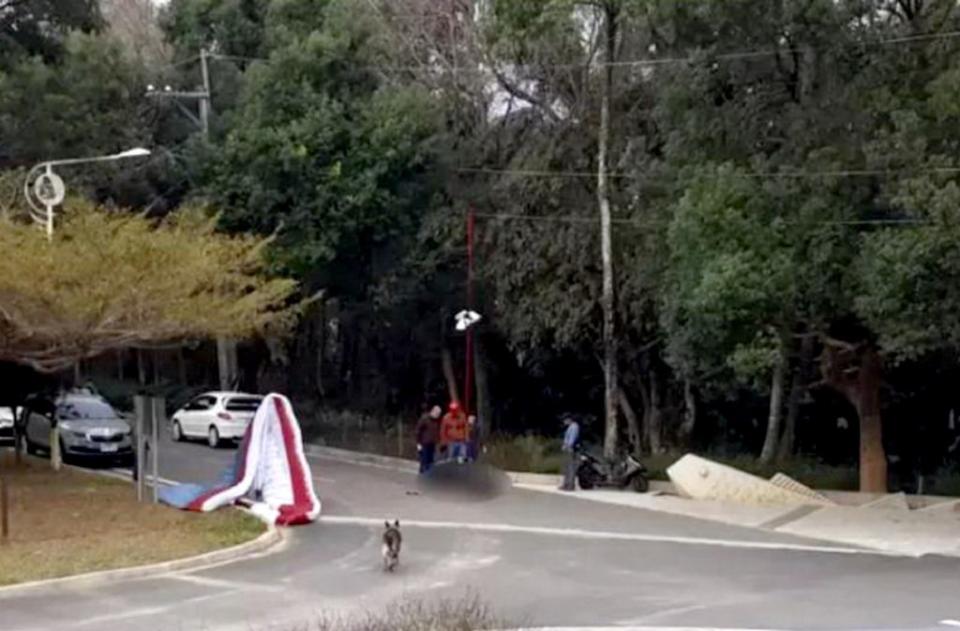 劉姓飛行傘玩家昨日準備降落鯉魚潭步道附近的飛行場草皮時，疑遭遇亂流，從高處失控墜地昏迷。（記者陳金龍翻攝）