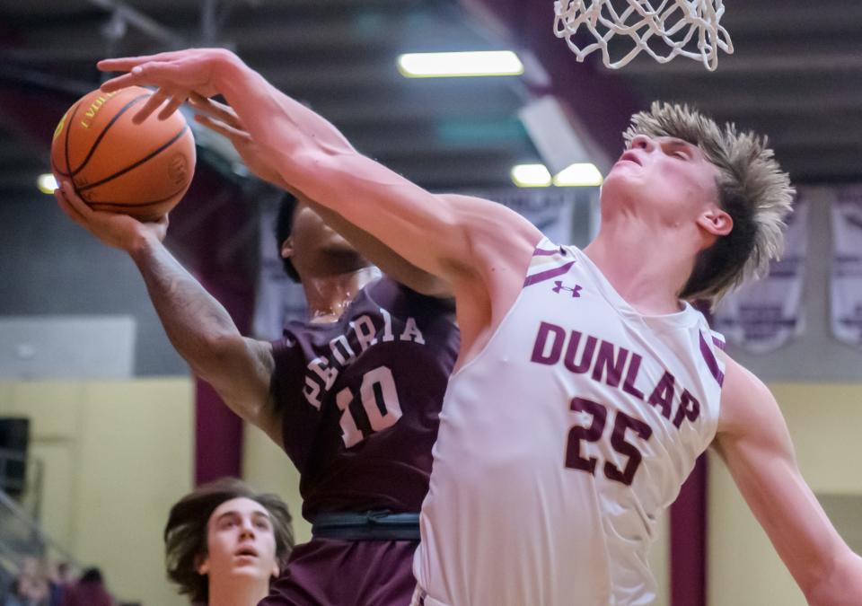 Dunlap's Mack Sutter (25) tries to stop a shot by Peoria High's Mikequese Taylor in the first half Tuesday, Jan. 17, 2023 at Dunlap High School. The Lions defeated the Eagles 71-46.