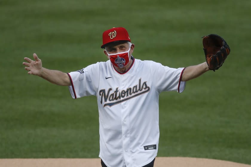 Dr. Anthony Fauci, Director of the National Institute of Allergy and Infectious Diseases, reacts after throwing out the ceremonial first pitch before the start of the first inning of an opening day baseball game between the New York Yankees and Washington Nationals at Nationals Park, Thursday, July 23, 2020, in Washington. (AP Photo/Alex Brandon)