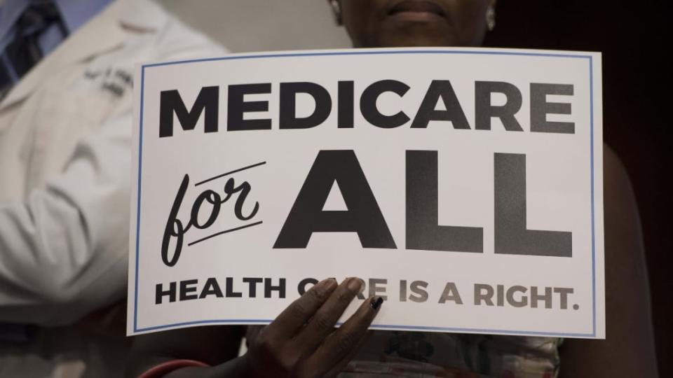 During a September 2017 discussion by Sen. Bernie Sanders about Medicare For All legislation, an audience member holds a sign touting the proposal. Second-time Democratic candidate Marianne Williamson says she would sign such legislation “with great joy.” (Photo: Jim Watson/AFP via Getty Images)