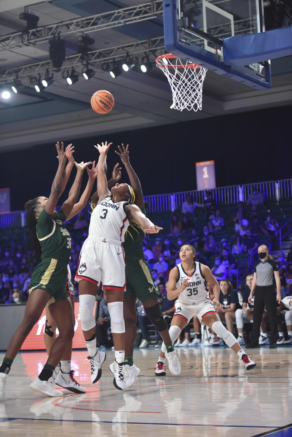 This photo provided by Bahamas Visual Services shows UConn forward Aaliyah Edwards (3) battling South Florida for the ball as UConn's Azzi Fudd (35) looks on during an NCAA college basketball game at Atlanta Paradise Island in Nassau, Bahamas, Sunday, Nov. 21, 2021. (Donald Knowles/Bahamas Visual Services via AP)