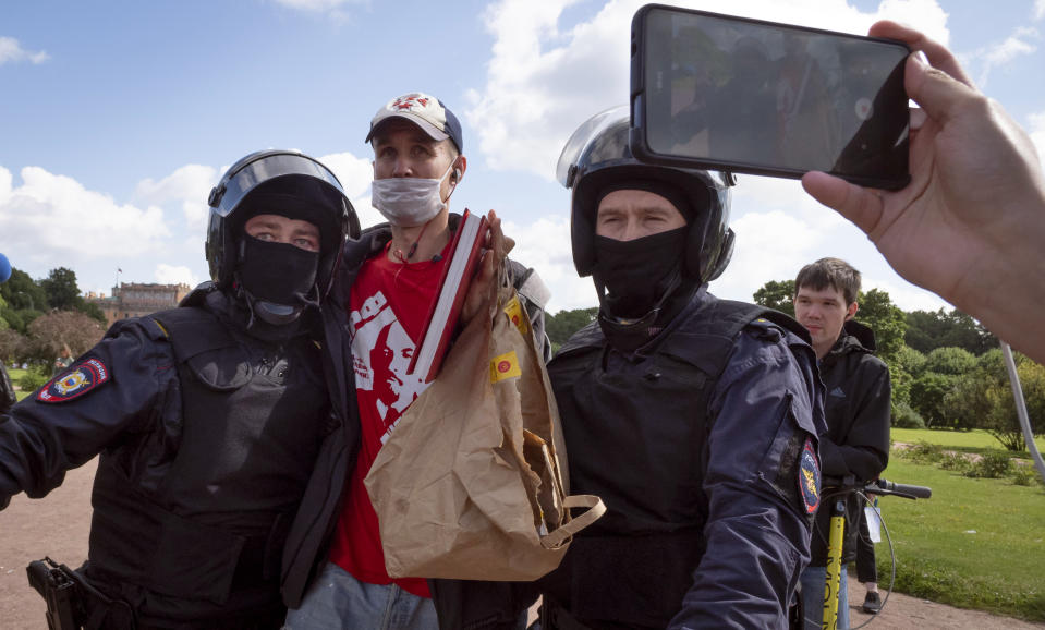 Police detain a protester during a rally supporting Khabarovsk region's governor Sergei Furgal in St.Petersburg, Russia, Saturday, Aug. 1, 2020. Thousands of demonstrators rallied Saturday in the Russian Far East city of Khabarovsk to protest the arrest of the regional governor, continuing a three-week wave of opposition that has challenged the Kremlin. (AP Photo/Dmitri Lovetsky)